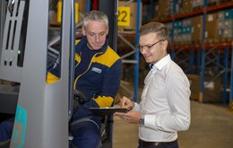 Mitarbeiter besprechen sich in einer Lagerhalle